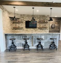 a bar with four stools and a television mounted on the wall in a room