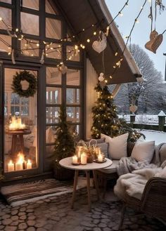 a cozy porch decorated for christmas with candles and wreaths