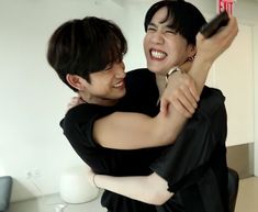 two people are hugging each other and smiling