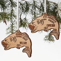 two wooden fish ornaments hanging from a tree