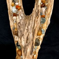 a piece of driftwood with various rocks and stones on it's sides, forming the letter v