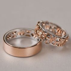 two gold wedding bands with diamonds on each one and an engagement ring in the middle