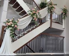 a staircase decorated with flowers and white drapes