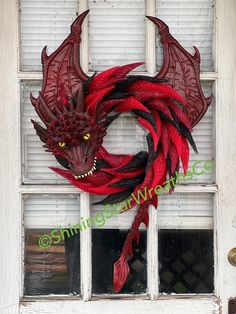 a red and black dragon wreath on a white door