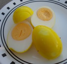 an egg is cut in half and placed on a white plate with black trim around the edges