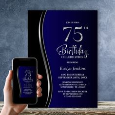 a person holding up a cell phone in front of a birthday party card with the number 75 on it