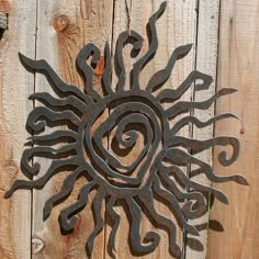 a metal sun on the side of a wooden fence