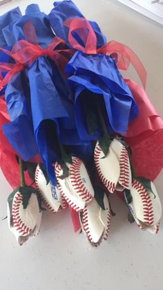 some baseballs are wrapped in red, white and blue paper with ribbons on them