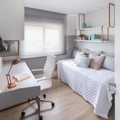 a white bed sitting next to a desk in a bedroom