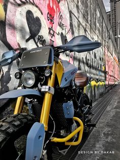 a motorcycle parked in front of a graffiti covered wall