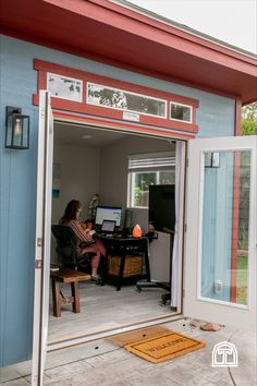 a woman sitting at a desk in an open garage door