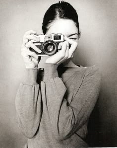 a woman holding up a camera to her face with the words be yourself on it