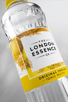 a bottle of london essence tonic water on a white background with the label in yellow and black