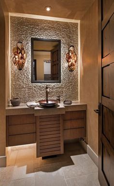 a bathroom with two sinks and lights on the wall