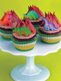 cupcakes decorated with colorful frosting and sprinkles on a cake stand