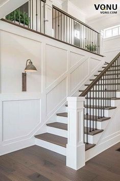 a white staircase with wood floors and wooden handrails