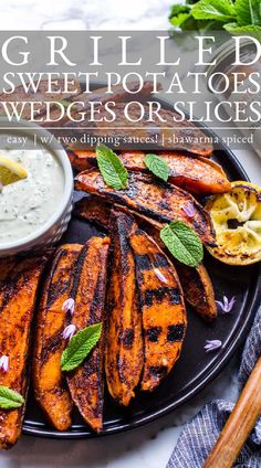 grilled sweet potato wedges on a black plate with dipping sauce and mint leaves