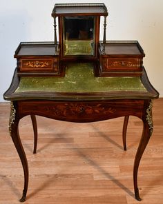 an antique desk with three drawers and a mirror on it's top, sitting on a hard wood floor