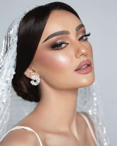 a woman wearing a veil and makeup looks off to the side with her eyes closed