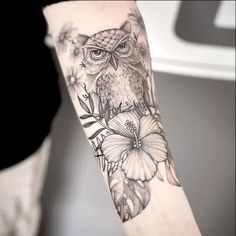 an owl and flowers tattoo on the arm