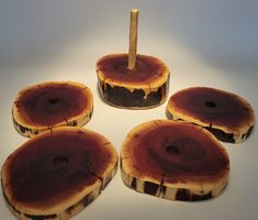 four pieces of wood sitting on top of a white table next to a wooden stick