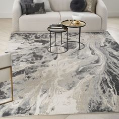 a living room with a white couch and marble rug