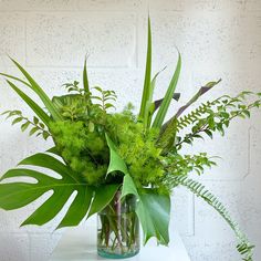 a vase filled with lots of green plants