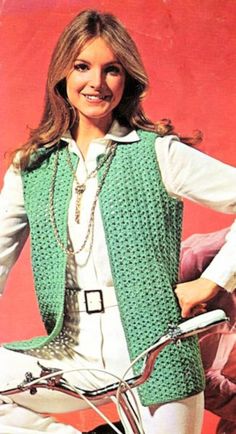 a woman wearing a green vest and white shirt