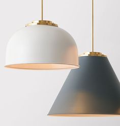 two white and gold pendant lights hanging from the ceiling, one with a light blue shade