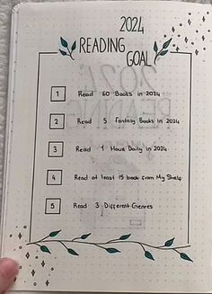 someone is holding up their reading goal book