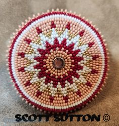 a red and white beaded basket sitting on top of a carpet