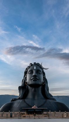 there is a large statue in front of the mountains