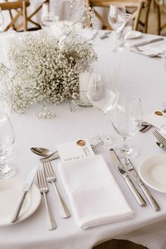 the table is set with silverware and place settings