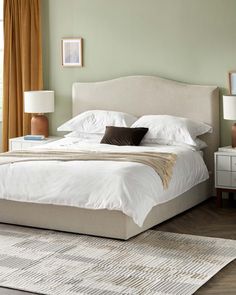 a large bed sitting in a bedroom on top of a wooden floor next to a window