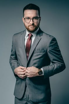 a man in a suit and tie is posing for the camera with his hands on his hips