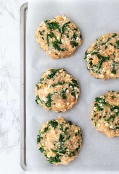 six cookies with spinach and cheese are on a baking sheet ready to go into the oven