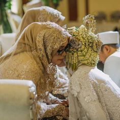 the bride and groom are dressed in traditional garb, veils and headpieces