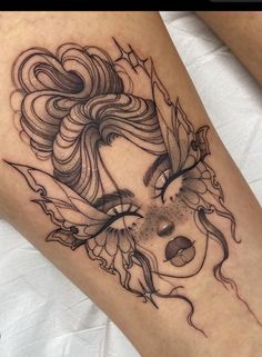 a woman's leg with an artistic tattoo design on the thigh and her face