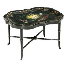 a black tray with flowers painted on it and gold trimmings around the edge