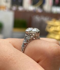 a close up of a person's hand holding an engagement ring