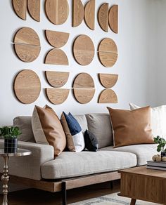 a living room filled with furniture and lots of wooden circles on the wall above it