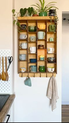 a wooden shelf filled with pots and pans next to a wall mounted pot rack