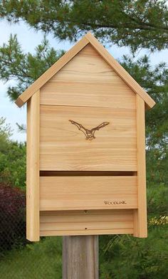 a wooden bird house with an eagle on it's face and the roof is made out of wood