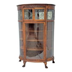 an antique display cabinet with glass doors and wood trimmings, in the shape of a bookcase