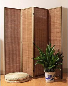 a room divider with a potted plant next to it on a wooden floor