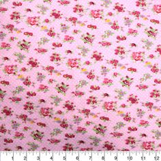 a pink flowered fabric with small flowers and dots on the bottom, along with a ruler