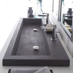 a bathroom sink sitting under a mirror next to a counter top with soap dispensers on it