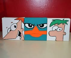 three cartoon characters painted on wood blocks