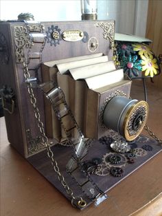 an old fashioned book with gears and chains attached to it on top of a table