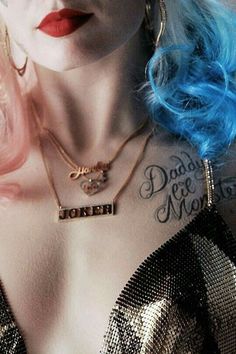 a woman with blue hair and tattoos on her chest